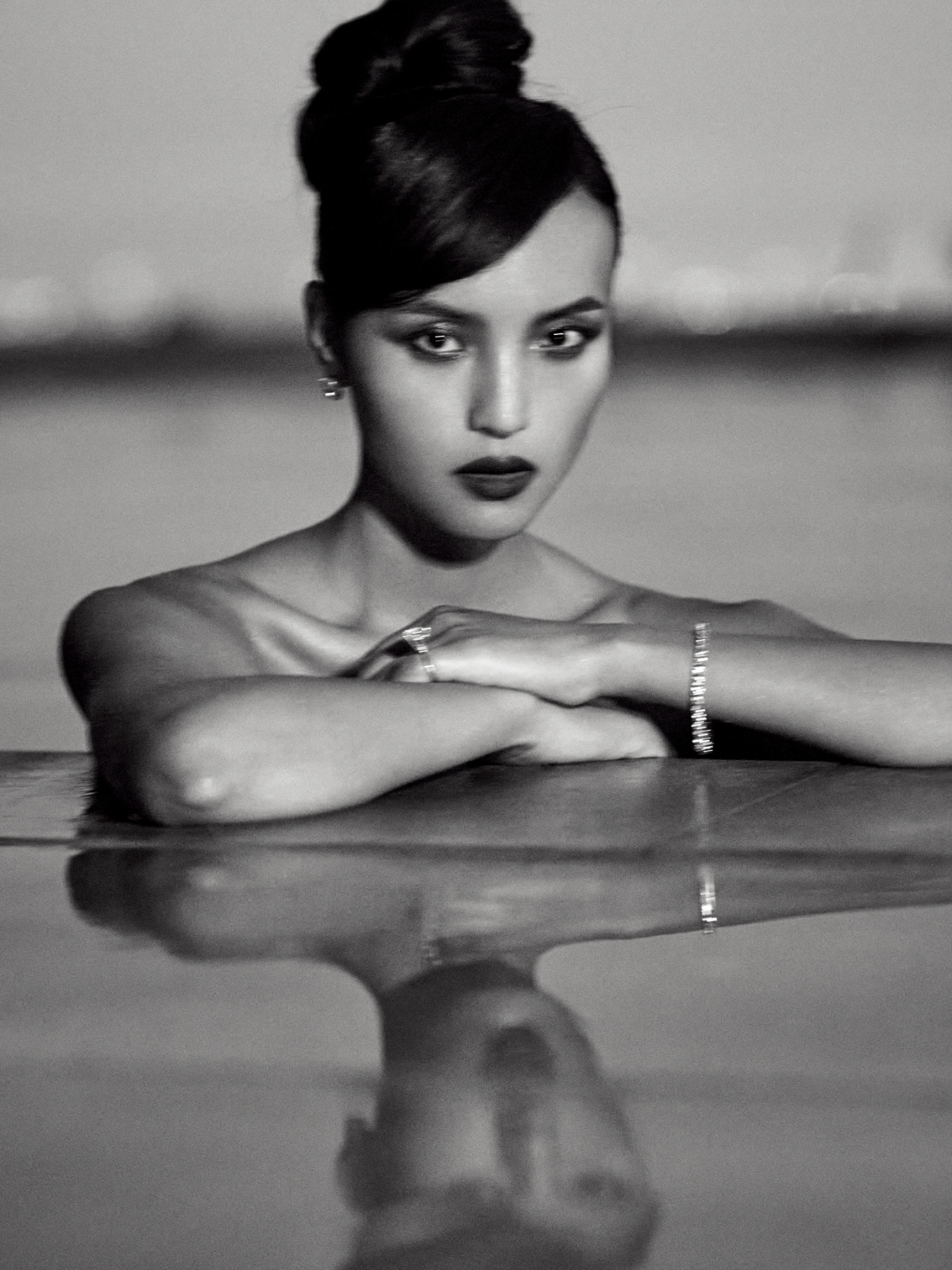 Model at the edge of a pool wearing diamond jewelry  